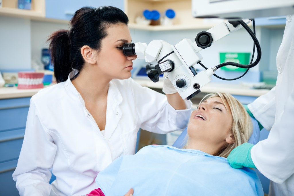 Dentist looking through microscope